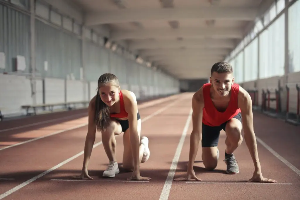 Men and Woman in Red Tank Top is Ready to Run on Track Field to Increase Metabolism